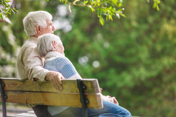 Elderly couple sitting on a bench.